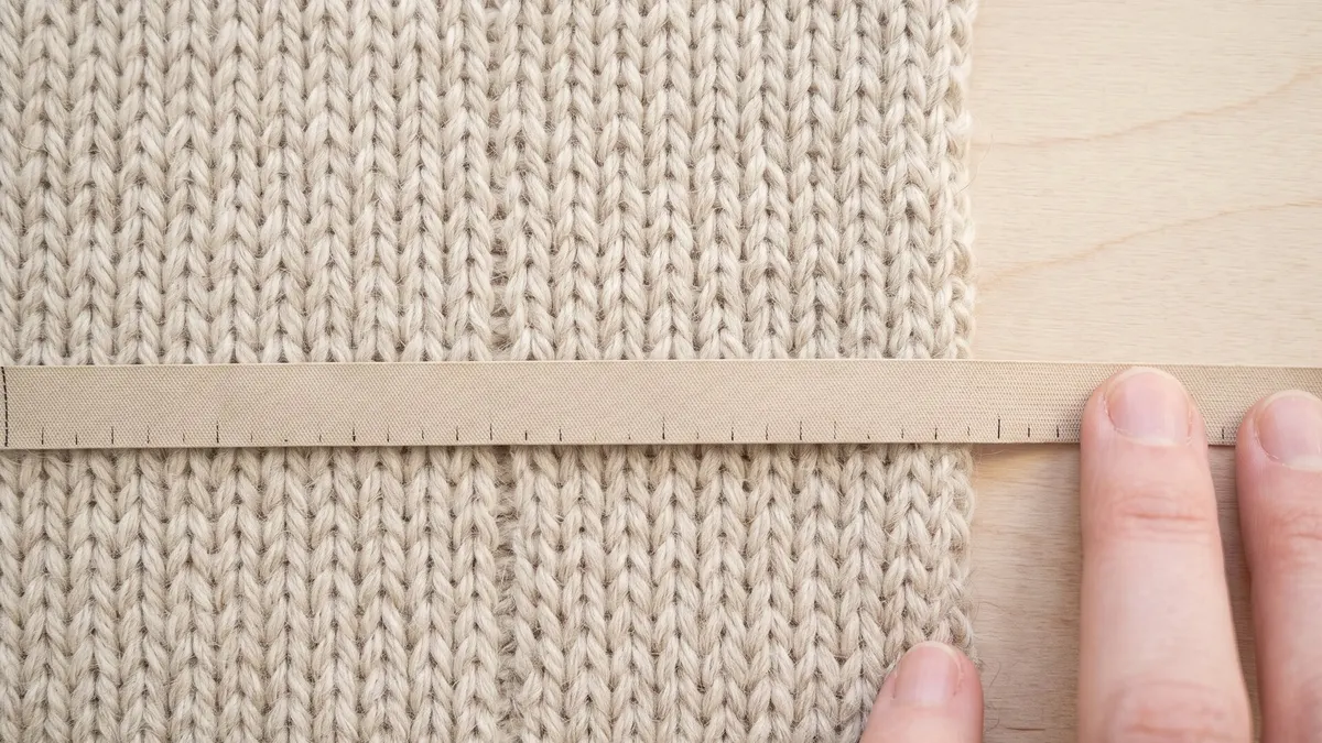 Ruler laid across a knitted gauge swatch