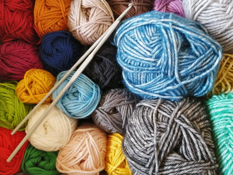 A collection of various knitting needles in wood and metal